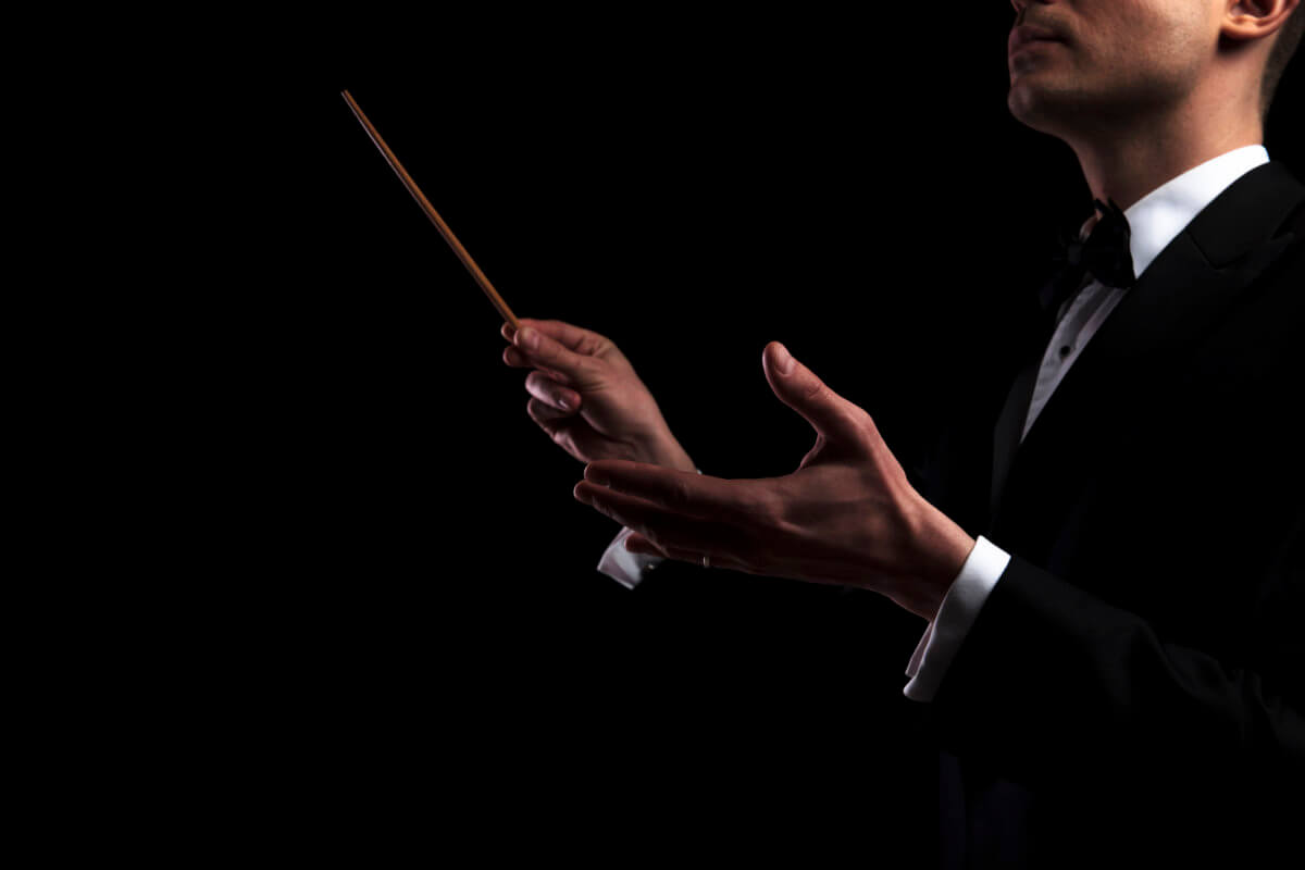 portrait of young orchestra conductor performing with a baton