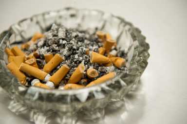 Ashtray full of ash and unlit cigarettes