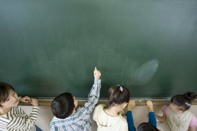 A boy writing on a blackboard