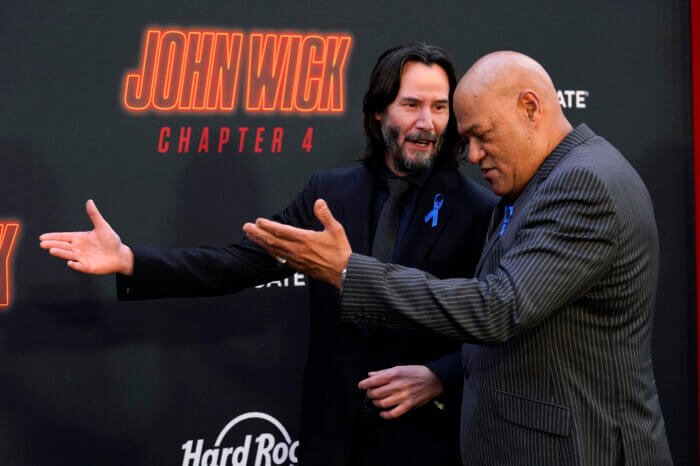 Keanu Reeves, left, and Laurence Fishburne, cast members in "John Wick: Chapter 4," walk the carpet together