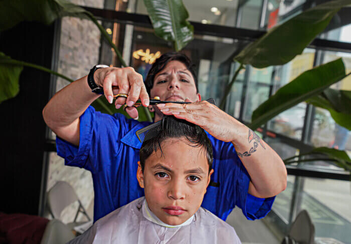Getting a trim at a makeshift hair salon in Long Island City, Queens