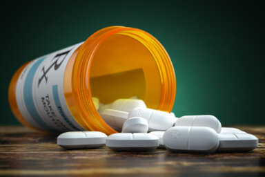 Pills spilling out from yellow container. Medical and pharmaceutical concept.