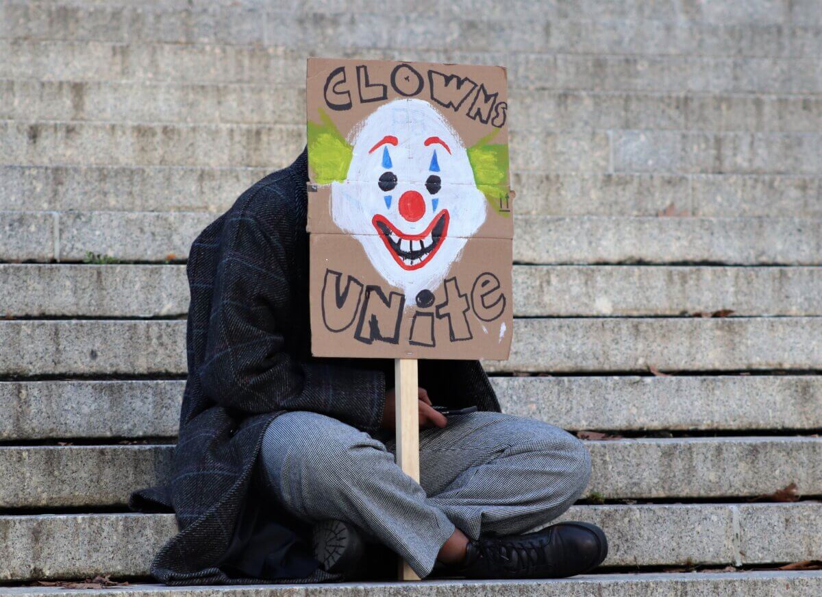 A man holding a Joker sign on the set of Joker 2, "Joker: Folie à Deux" (Photo by Michael Dorgan)