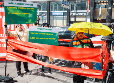 Street vendors stand behind the proverbial red tape.