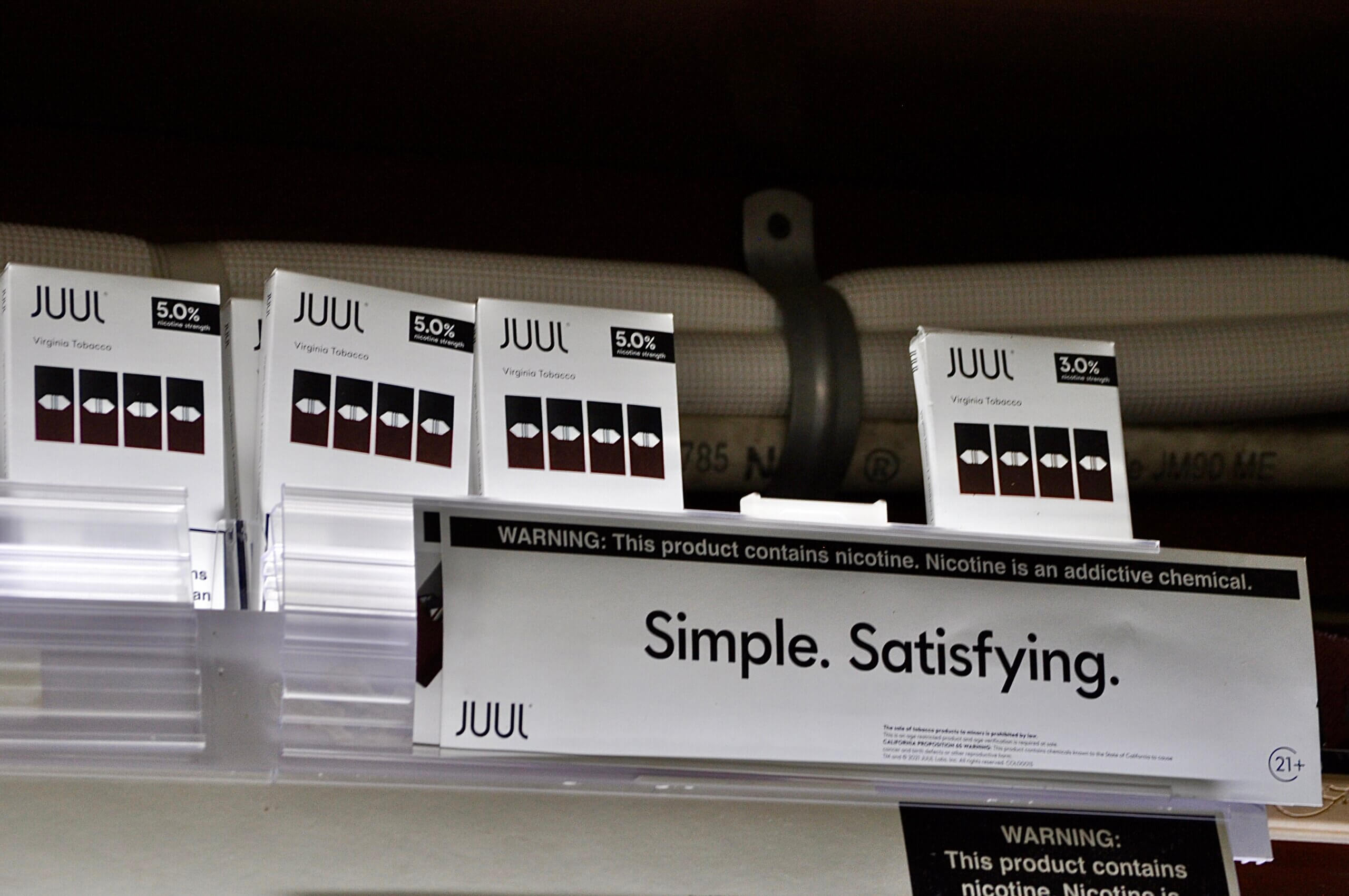 JUUL products and its "Simple. Satisfying." slogan at a smoke shop