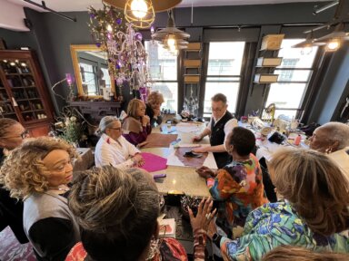 Anthony Luciano (back center) teaches a Sip & Stitch class in New York City.