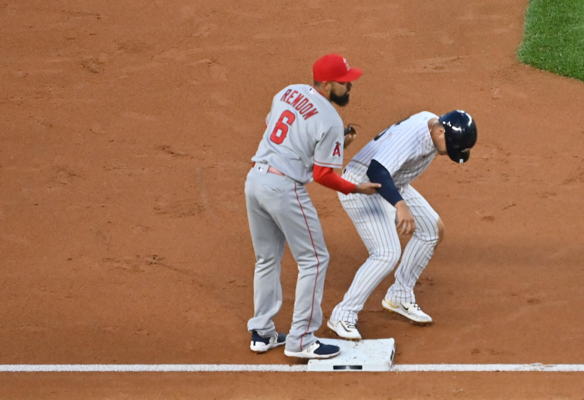 Los Angeles Angels infielder Anthony Rendon grabs the arm of a Yankees player while at third base on April 18, 2023.