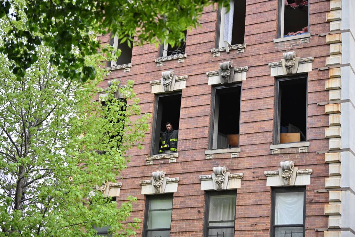 Firefighter looks out of scene of deadly Brooklyn fire