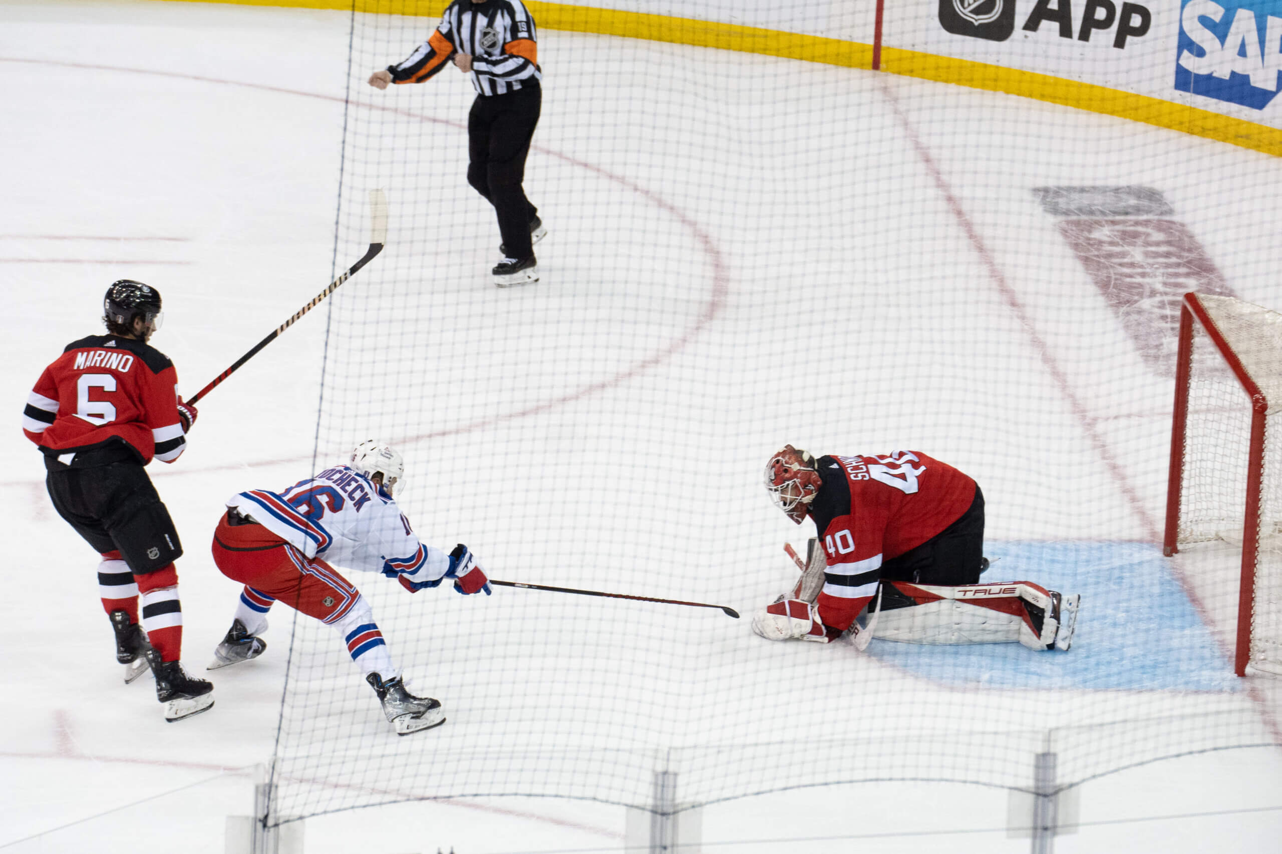 Devils goaltender Akira Schmid covers up the puck as Rangers forward Vincent Trocheck tries to poke at it during Game 7 of the first round of the Stanley Cup Playoffs on May 1, 2023.