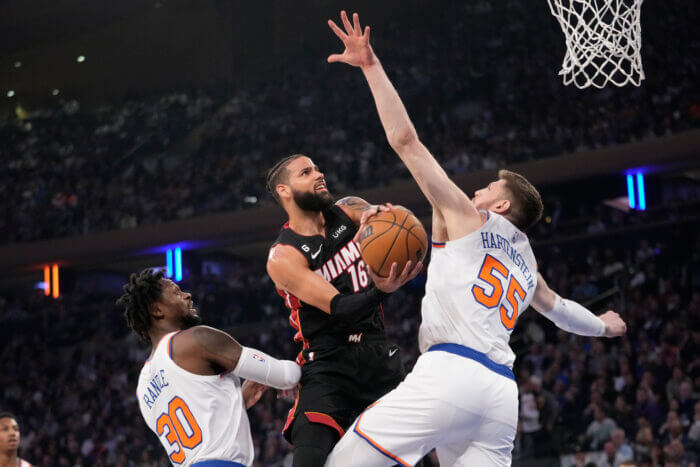 Caleb Martin drives against Isaiah Hartenstein of the Knicks