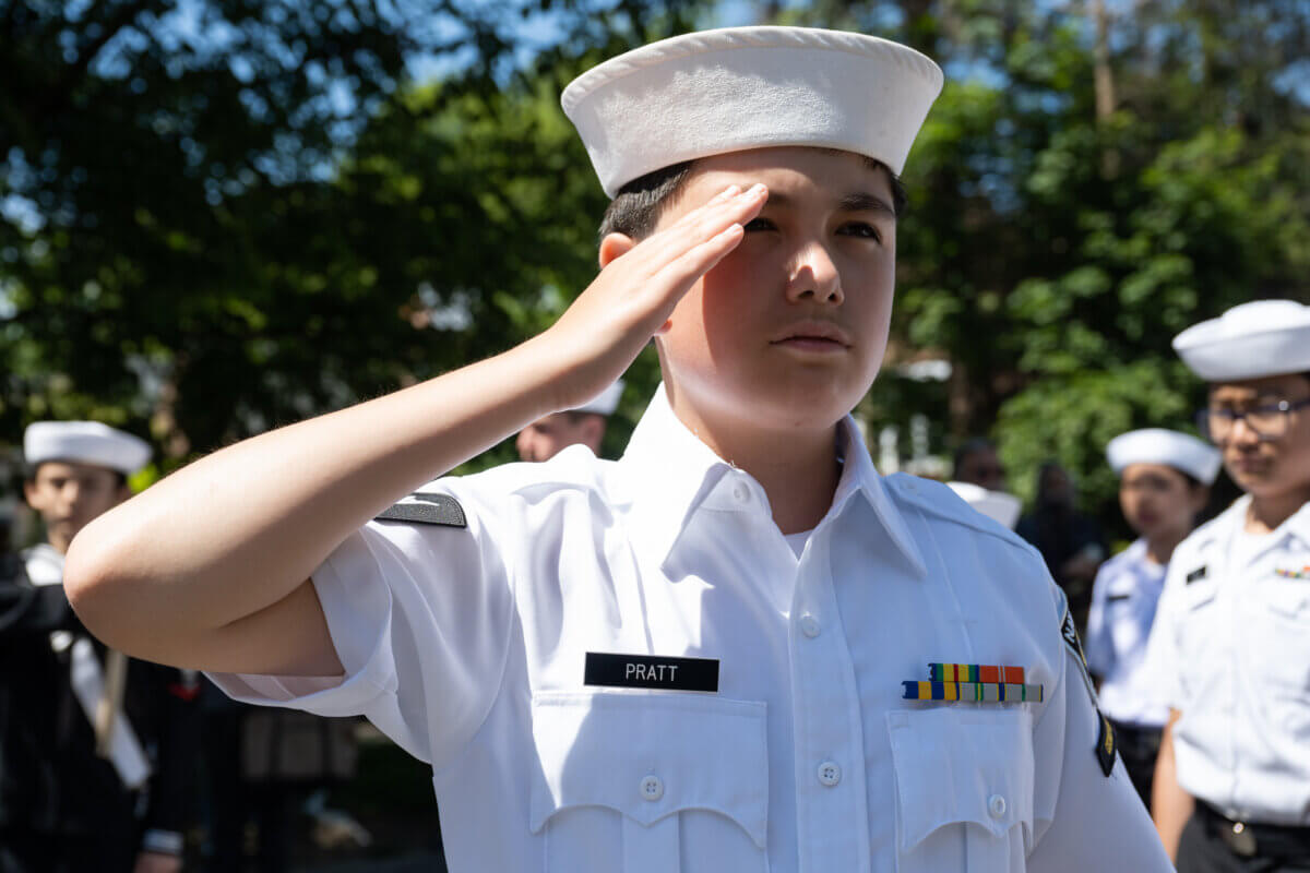 A young cadet stands in salute during the rendition of the American Anthem