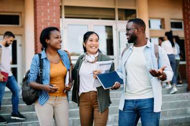 Multiracial group of happy students talking and having fun after the lecture at campus.