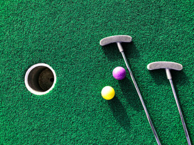 Mini golf clubs and balls on putting green