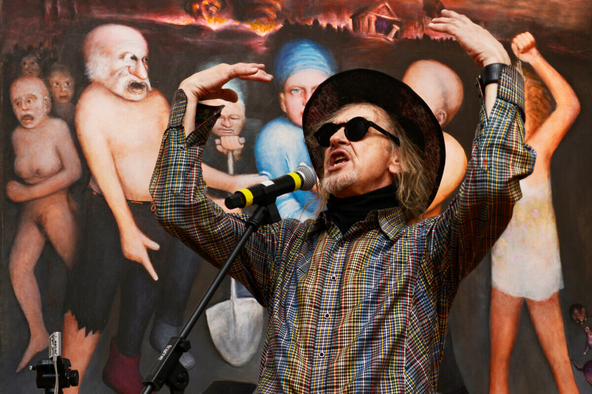 Walter Steding performing in front of his painting "The Fall of Boaz"