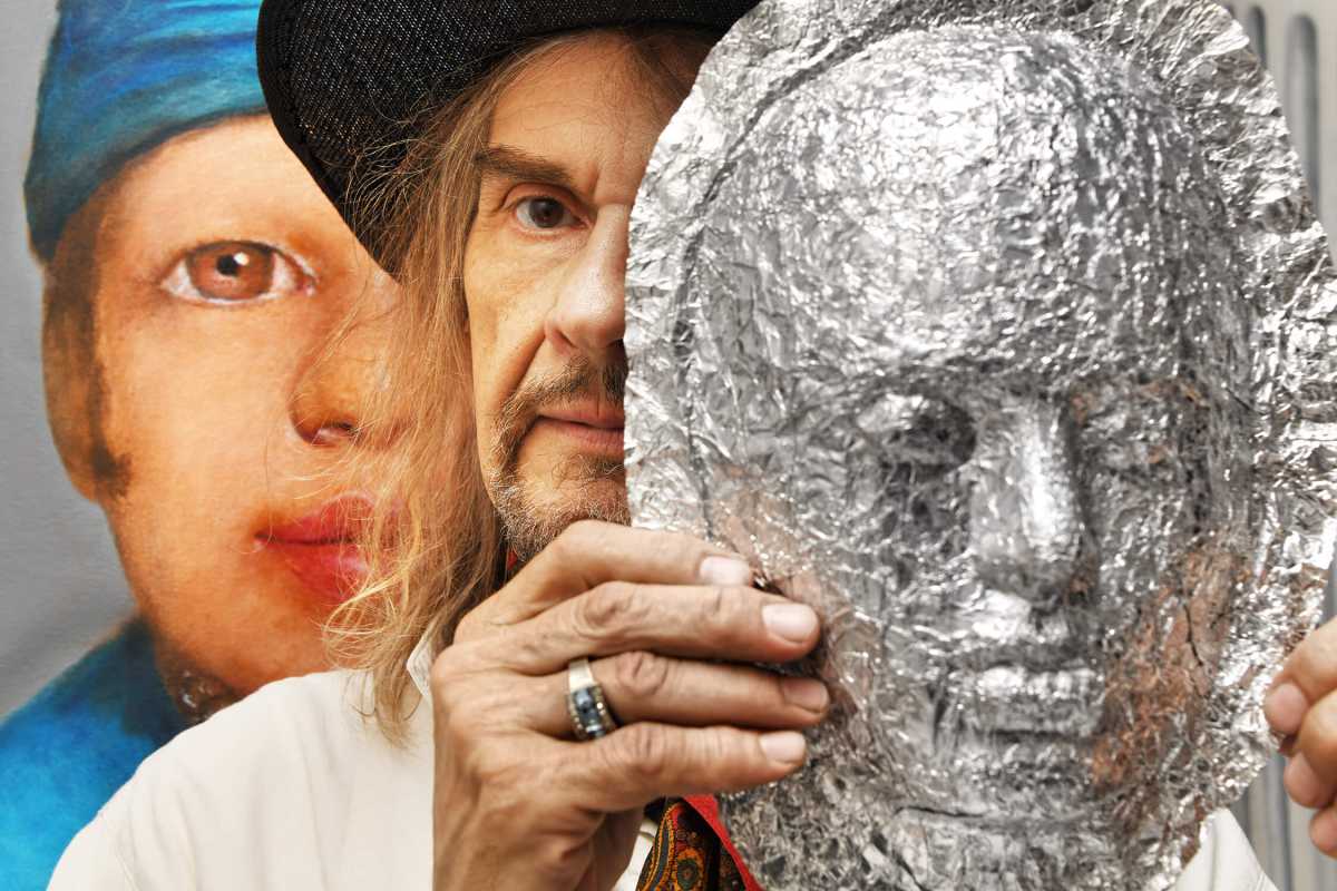 Artist Walter Steding with a mask he created