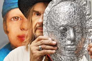 Artist Walter Steding with a mask he created