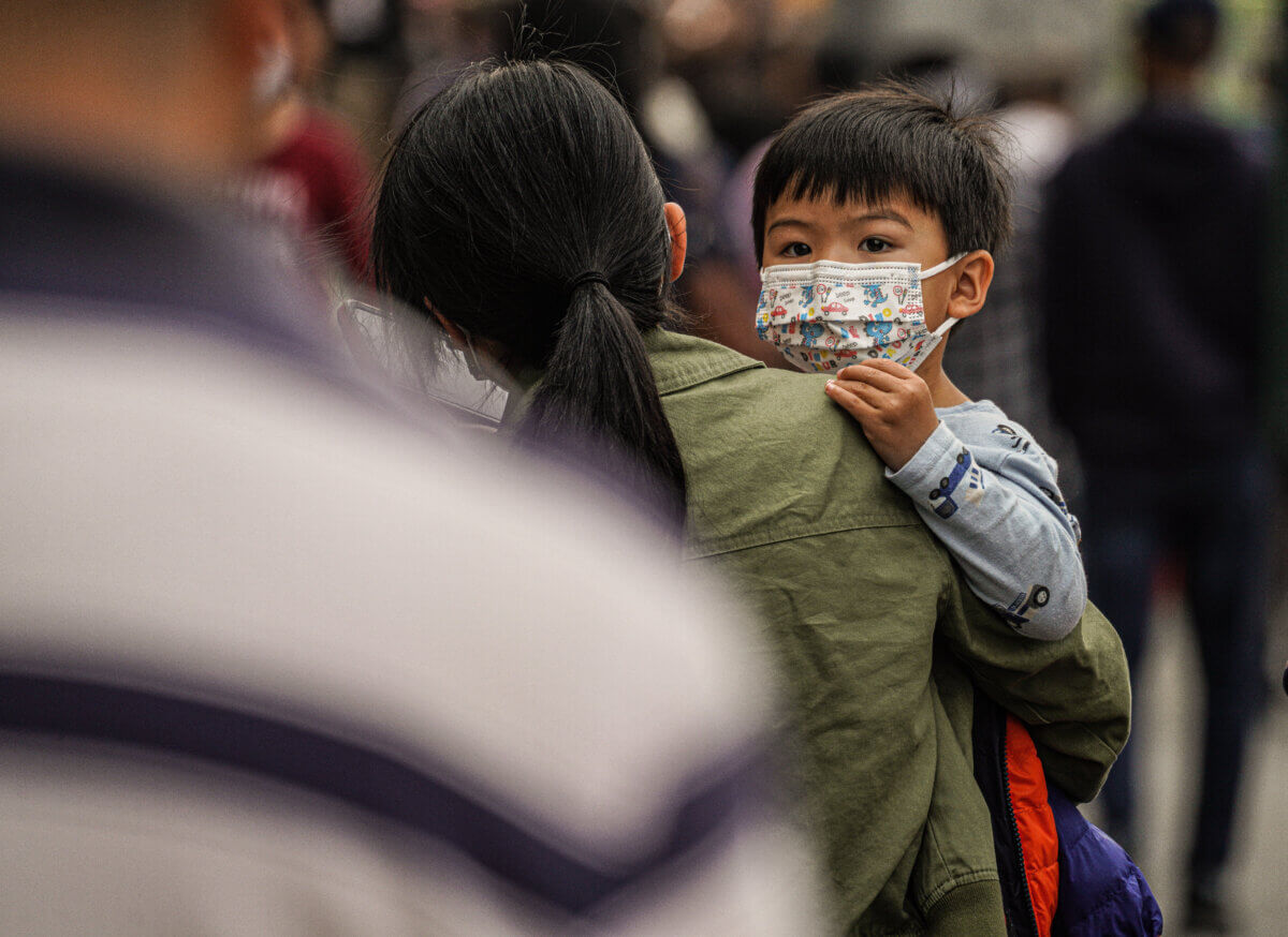 Child with mask during poor air quality and smoke filled skies in Queens