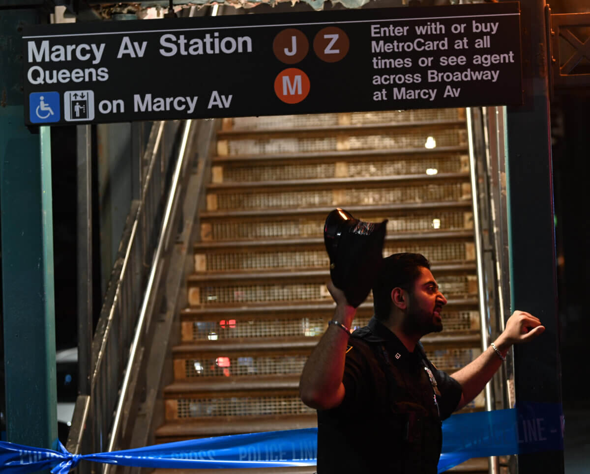An officer guards a crime scene at the Marcy Av station