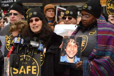 Amy Cohen, co-founder of Families for Safe Streets, next to a picture of her son Sammy, the namesake of Sammy's Law, at a 2019 rally.