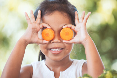 Cute asian child girl having fun to learn about vegetables