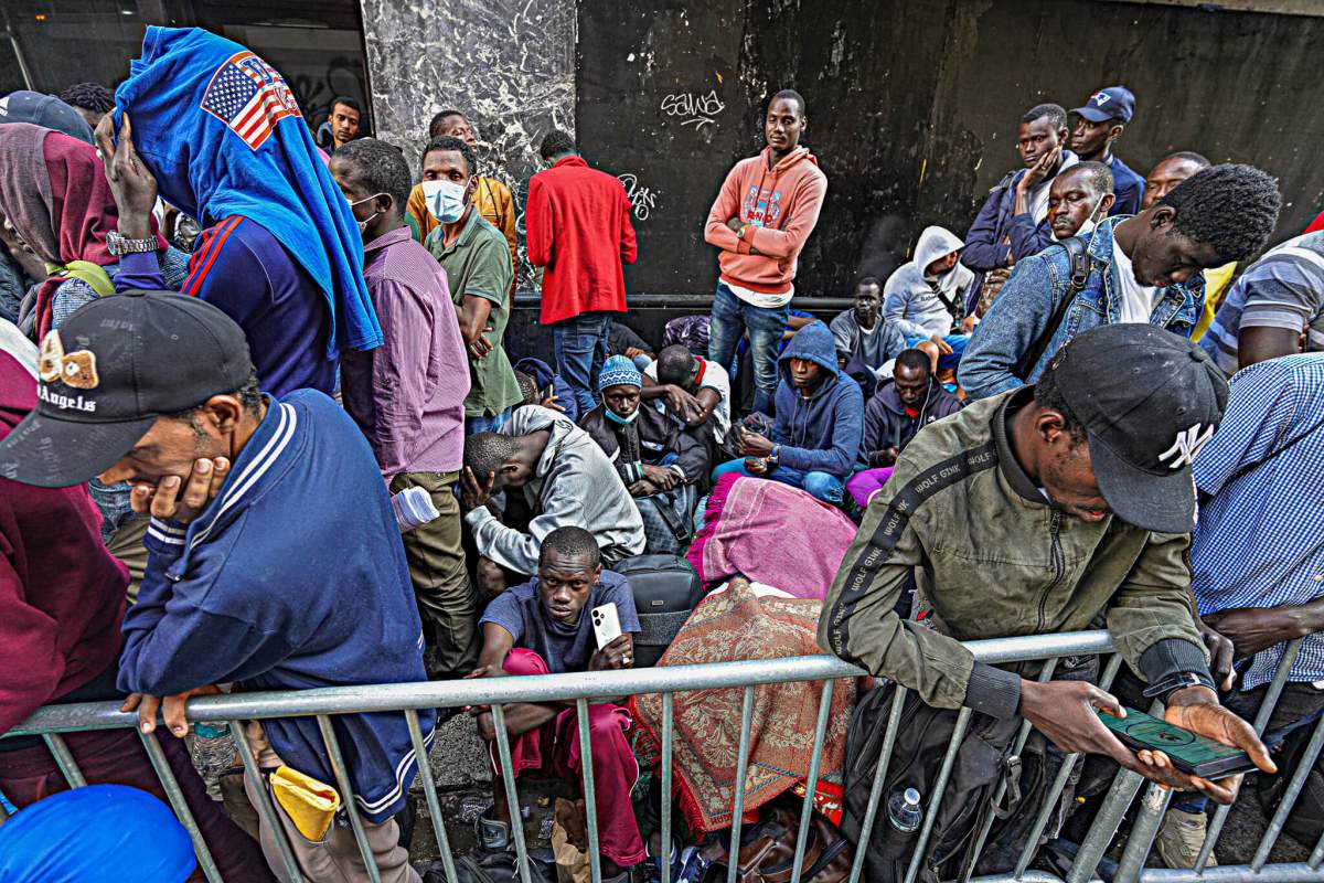 Migrants huddled outside of the Roosevelt Hote