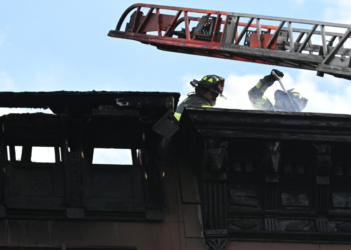 Firefighters work to ventilate a roof during the inferno