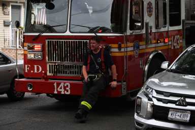 A firefighter takes a rest after operating at a house fire at 106-55 96 Street.