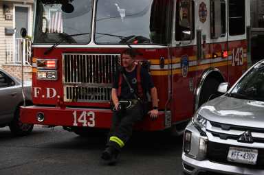 A firefighter takes a rest after operating at a house fire at 106-55 96 Street.