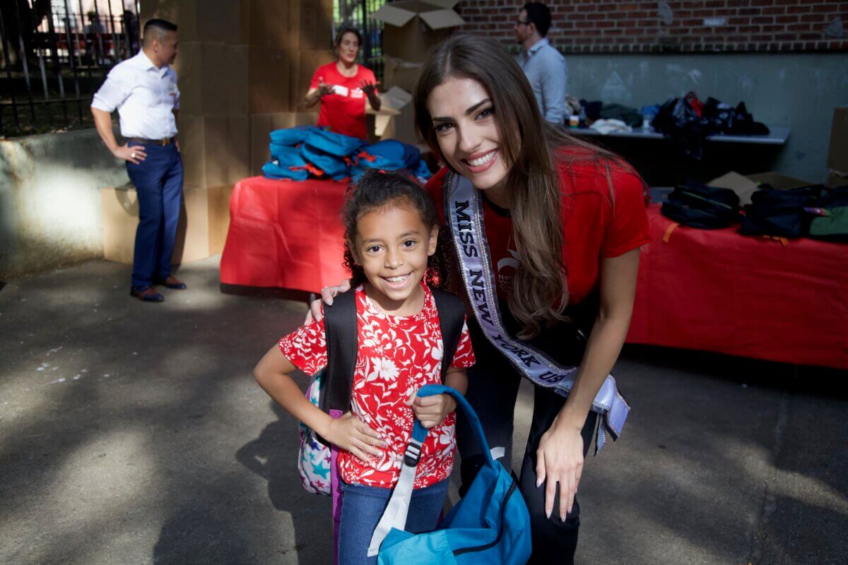 Miss New York with young girl at East Village school supply giveaway