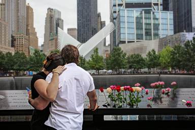 A couple embrace at the 9/11 memorial in Lower Manhattan