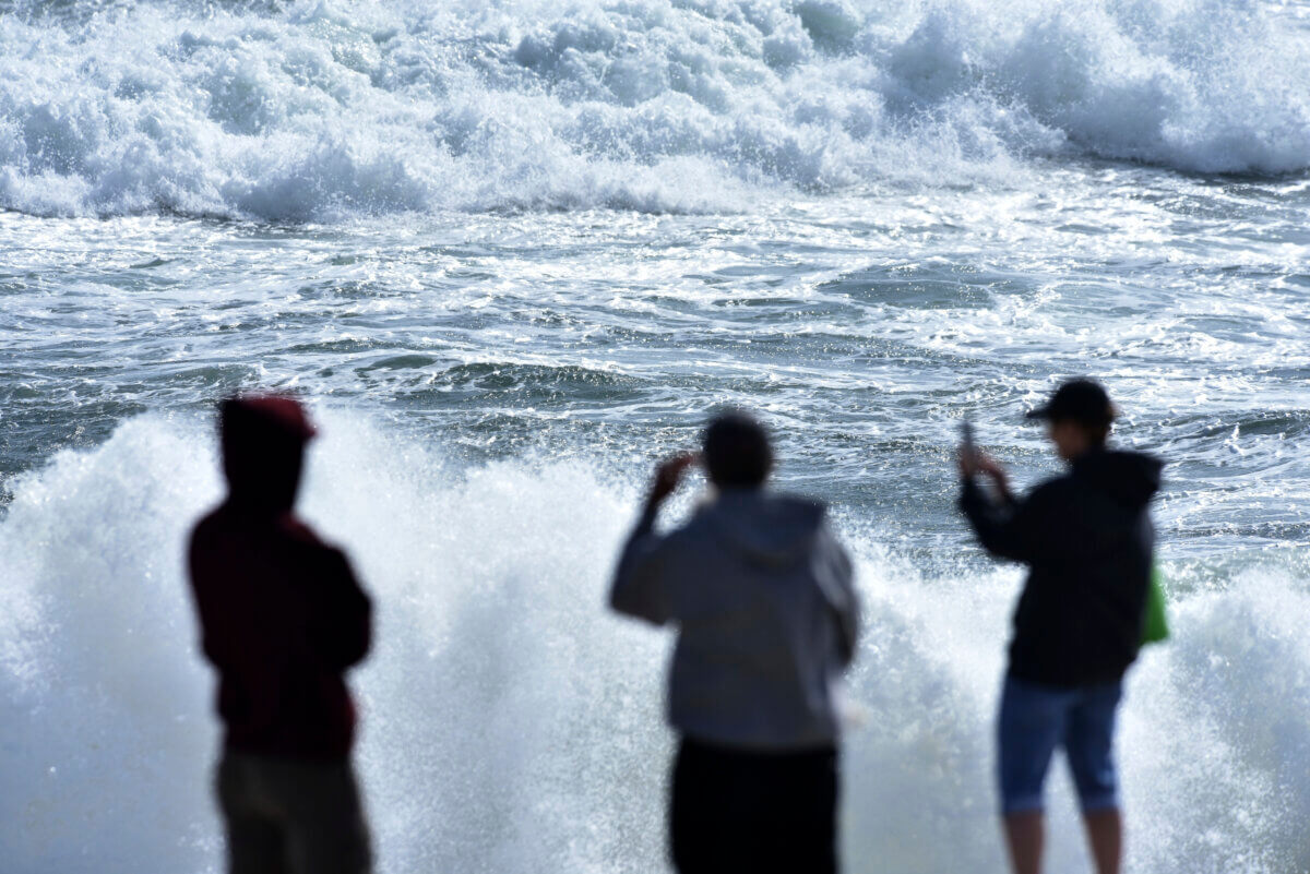 People watch heavy waves from Hurricane Lee