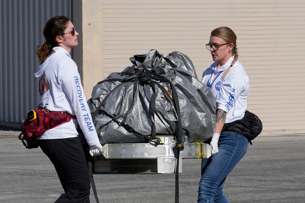 Recovery team members carry a capsule containing NASA's first asteroid samples to a temporary clean room at Dugway Proving Ground in Utah on Sunday, Sept. 24, 2023. The Osiris-Rex spacecraft released the capsule following a seven-year journey to asteroid Bennu and back.