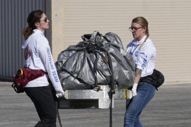 Recovery team members carry a capsule containing NASA's first asteroid samples to a temporary clean room at Dugway Proving Ground in Utah on Sunday, Sept. 24, 2023. The Osiris-Rex spacecraft released the capsule following a seven-year journey to asteroid Bennu and back.