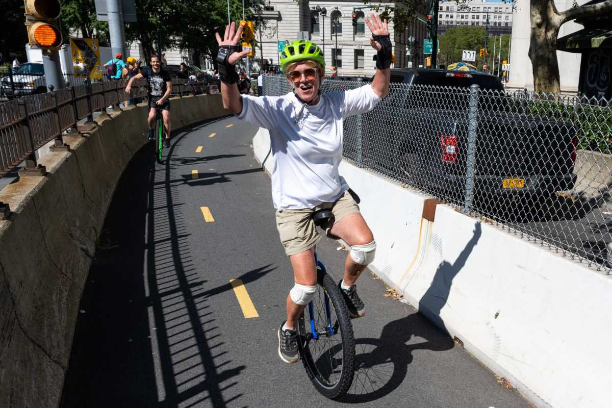 Man on unicycle riding on Brooklyn Bridge