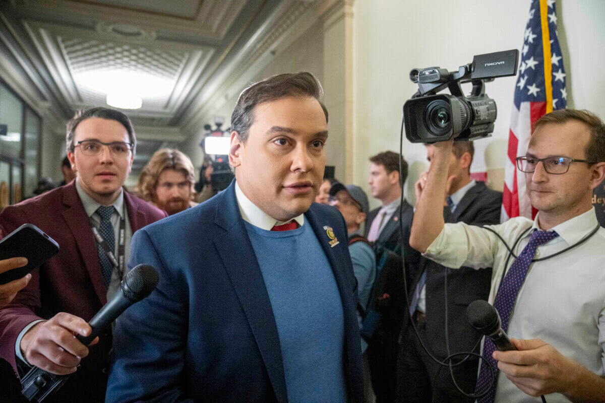 George Santos walking surrounded by reporters