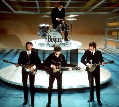 The Beatles, foreground from left, Paul McCartney, George Harrison, John Lennon and Ringo Starr on drums perform on the CBS "Ed Sullivan Show" in New York on Feb. 9, 1964.