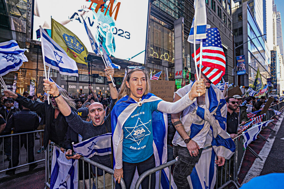 Israel supporter at protest holding American flag