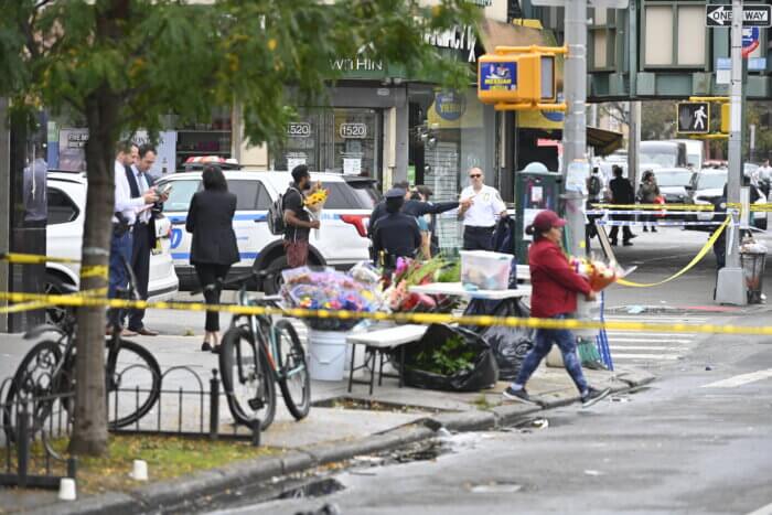 Spectators crowd around the scene of the shooting, which occurred just after noon on Friday.