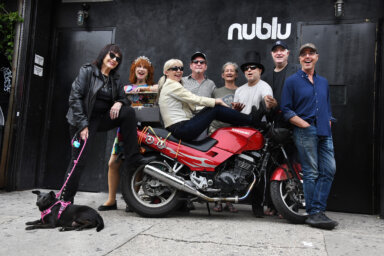 East Village artists pose in front of motorycle