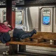 Homeless individual on subway bench