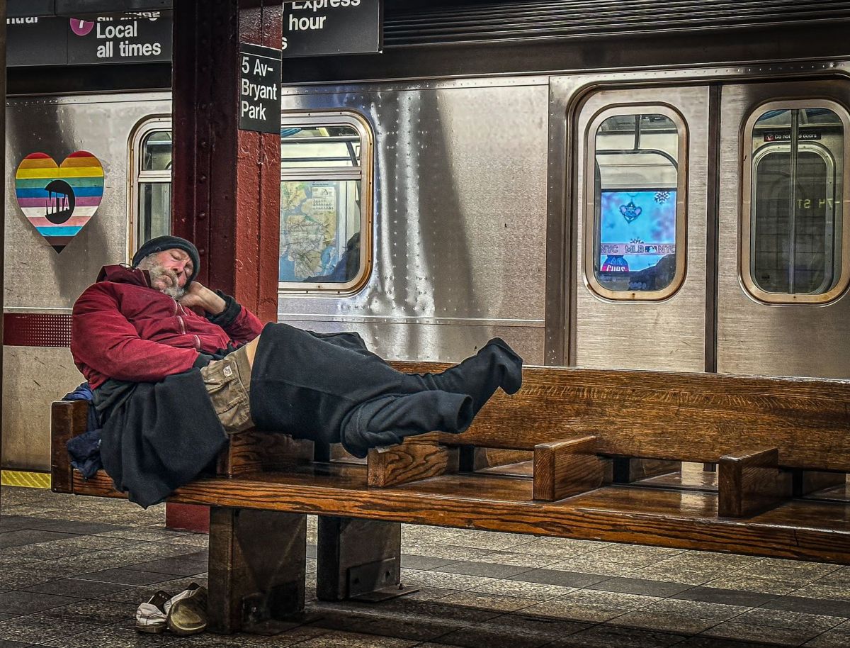 Homeless individual on subway bench