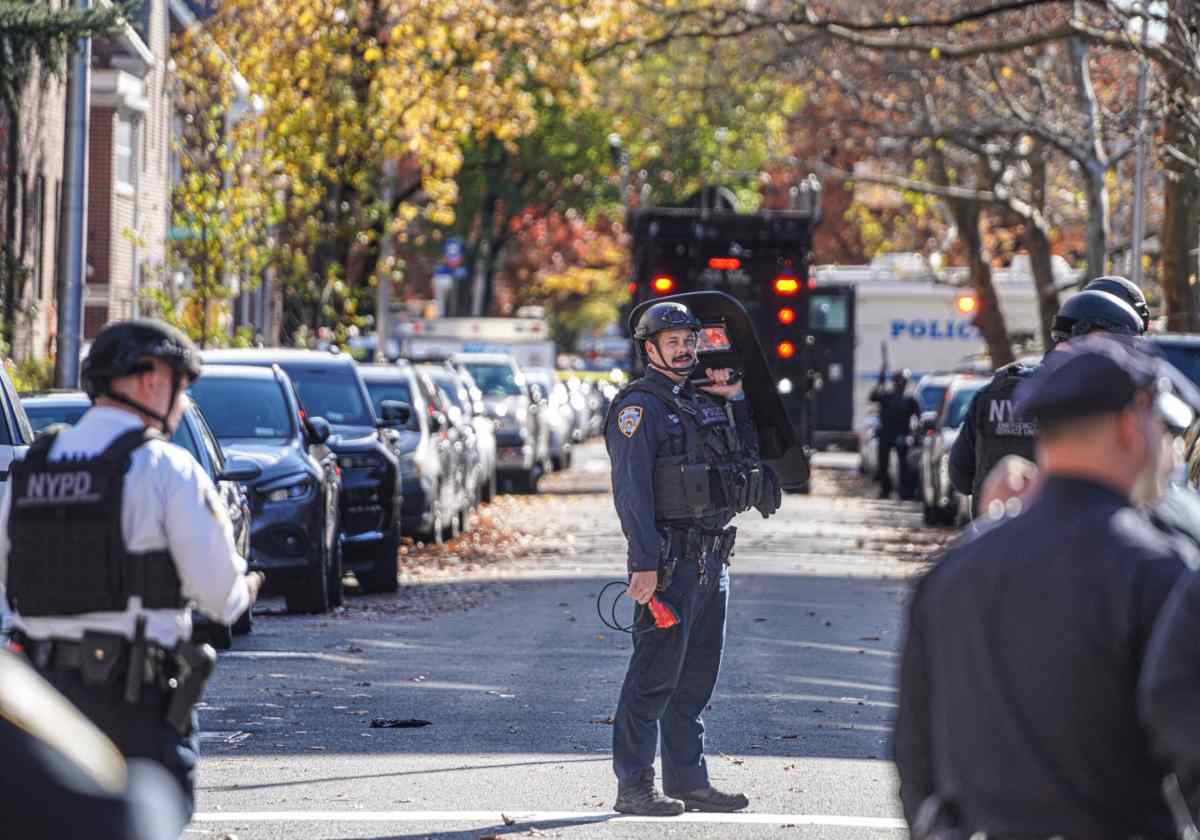 Officer holds shield at Queens shootout standoff crime