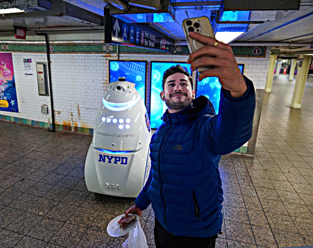 A straphanger takes a selfie with the K5 robot in Times Square.
