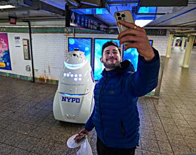 A straphanger takes a selfie with the K5 robot in Times Square.