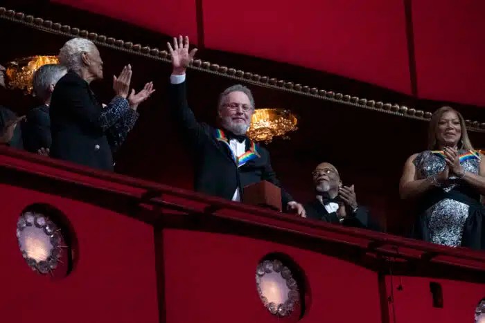 2023 Kennedy Center Honoree, comedian Billy Crystal, center, waves as he is applauded by fellow honorees Dionne Warwick and Queen Latifah, at the 46th Kennedy Center Honors at the John F. Kennedy Center for the Performing Arts in Washington, Sunday, Dec. 3, 2023.