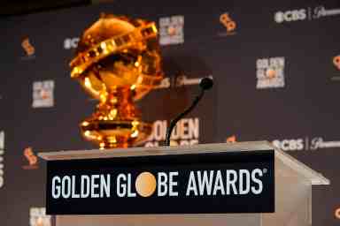 A replica of a Golden Globe statue appear behind the podium