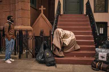 Migrant sleeping on stoop of building
