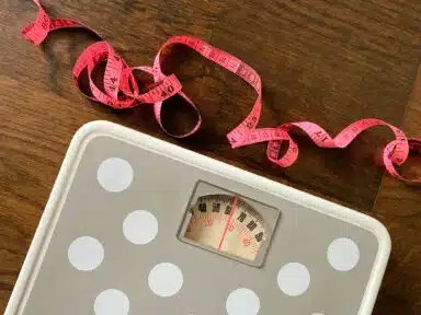 Weight scale and measuring soft tape close up image. Fitness and weight loss concept