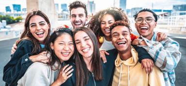 Happy group of young people smiling at camera outdoors – Smiling friends having fun hanging out on city street – University students standing together in college campus – Friendship and youth concept