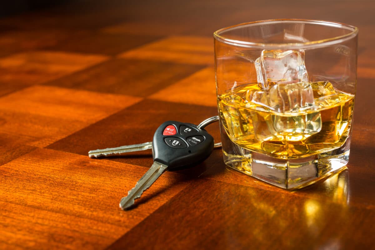 Drunk driving composite: car keys with alcoholic drink